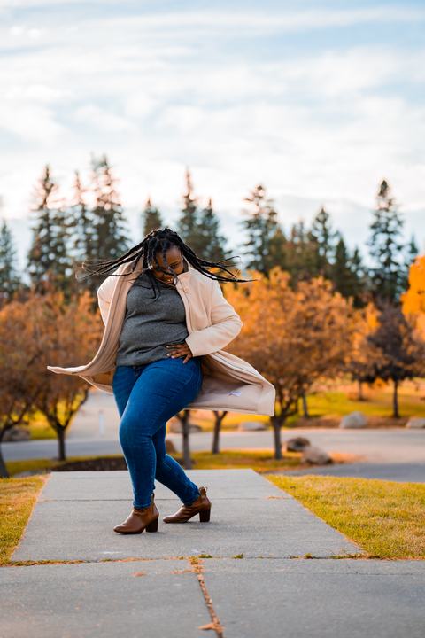 Lifestyle portrait, coat swirling in autumn trees